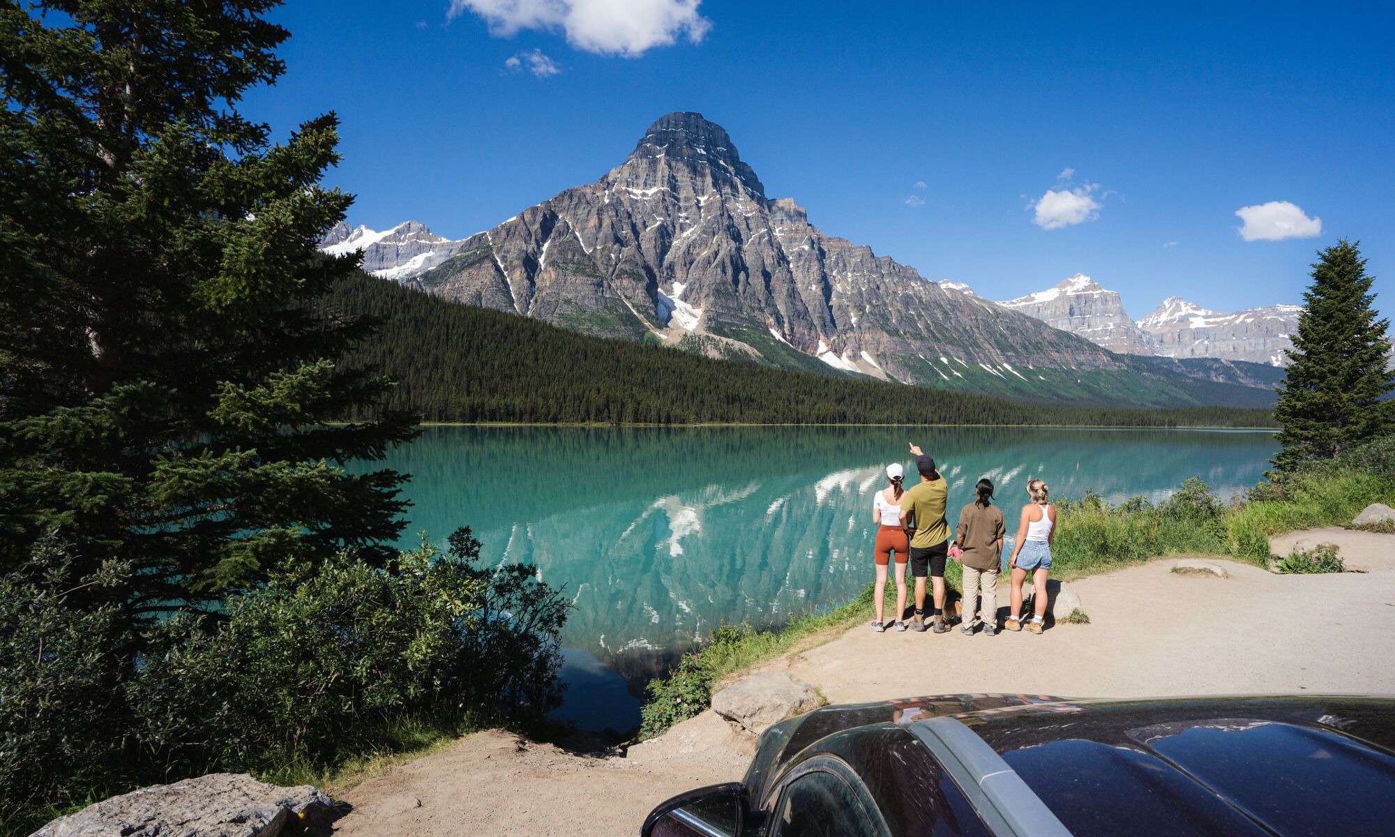 A group stands on the edge of Waterfowl Lakes in Banff National Park.